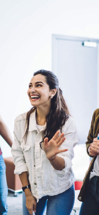 Une jeune souriante au tableau de la classe qui suit une formation disc