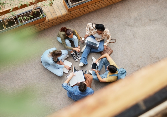 Study, university group and students on floor for research, project or planning, brainstorming and teamwork. Technology, education and top of college friends or people circle in school collaboration
